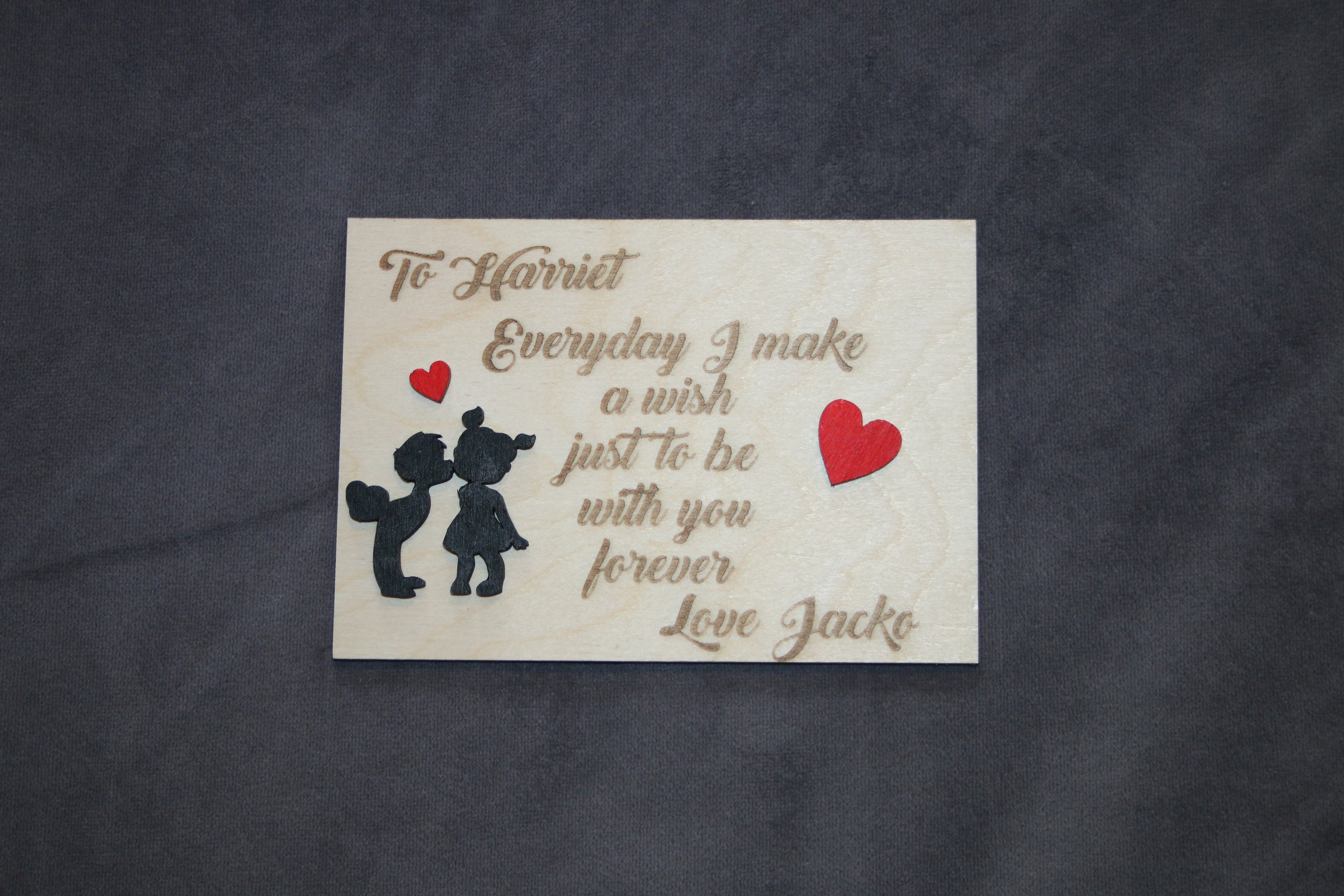 Personalized wooden love message plaque with engraved text, heart accents, and silhouette design