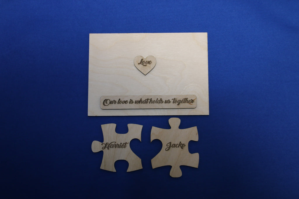 Disassembled personalized wooden puzzle plaque showing name pieces, heart, and engraved message